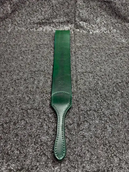 Green leather strap on a textured gray surface